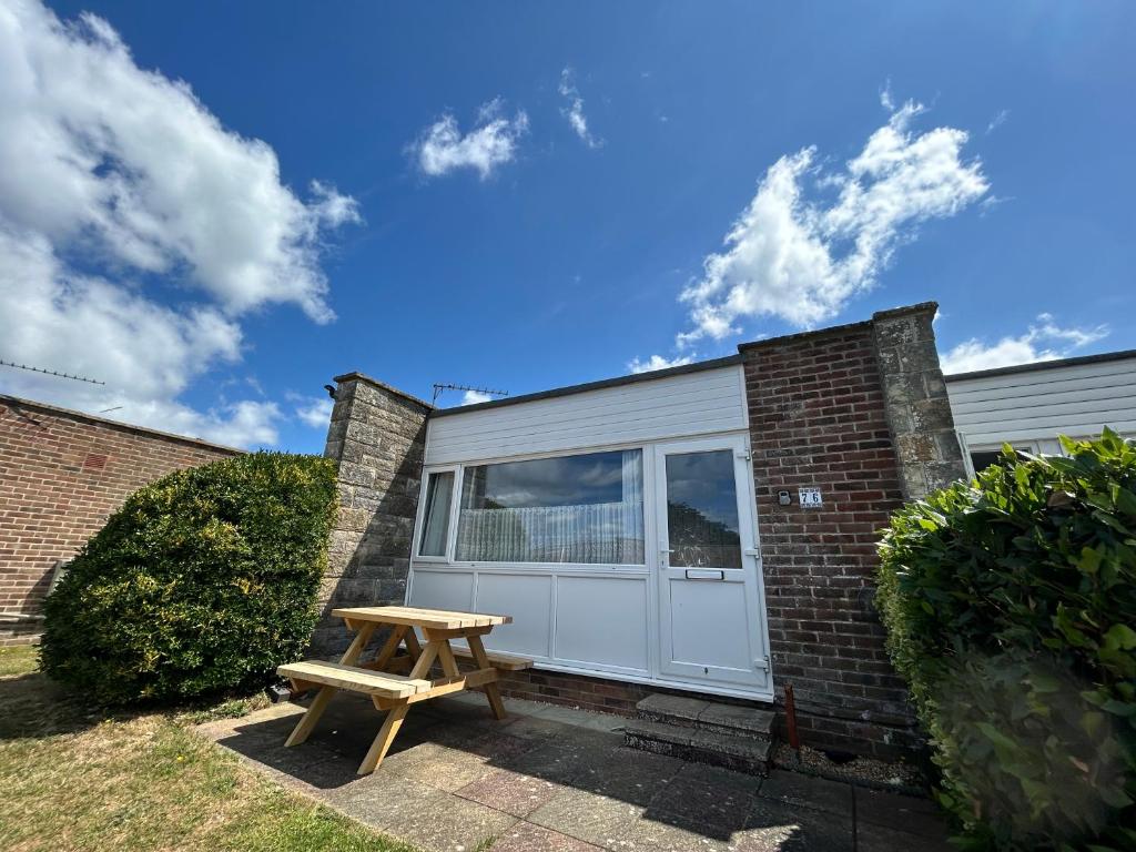 a picnic table in front of a garage at 76 Brambles Chine, 2 bedroom bungalow in beautiful holiday village, 1 night stays and Ferry travel offer available in Isle of Wight