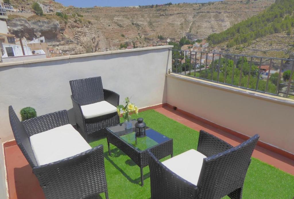 a balcony with chairs and a table with a view at Casa rural Butaka in Alcalá del Júcar