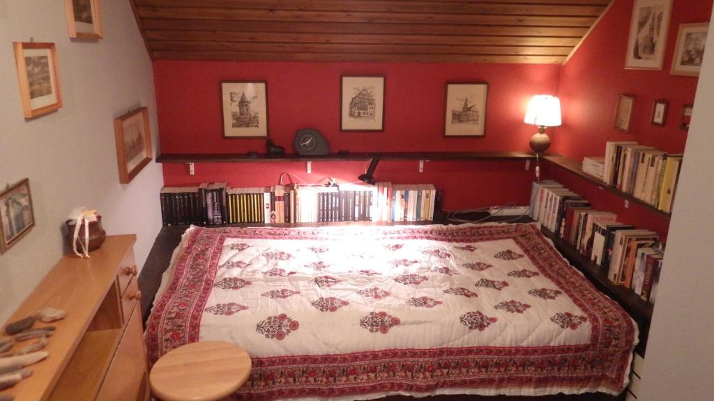ein Schlafzimmer mit einem Bett mit einer roten Wand in der Unterkunft Ferienhaus Frieda in Kurort Altenberg