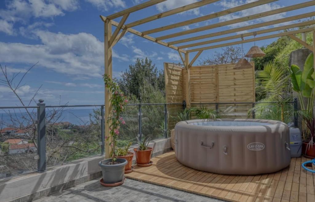 een hot tub op een terras met een pergola bij Valley Canhas I in Relógio do Poiso
