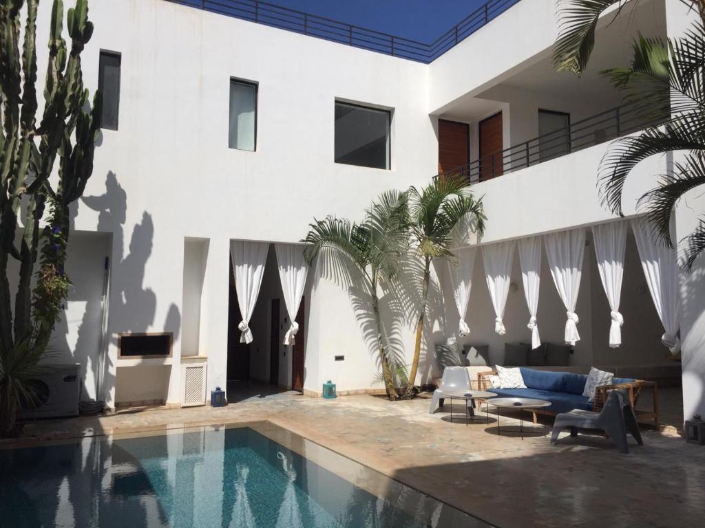 a house with a swimming pool next to a building at Villa blanche in Mirleft