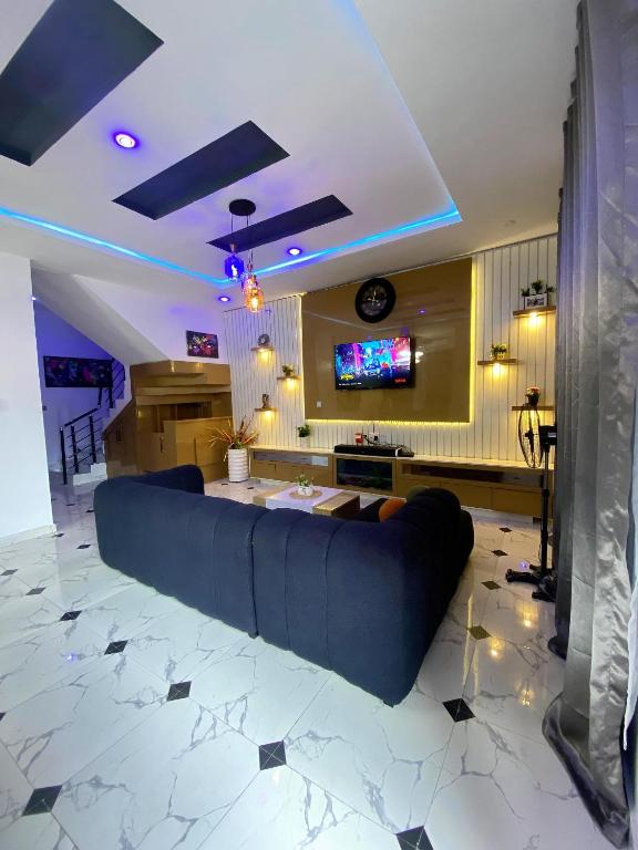 a large couch in a living room with a tv at Kstephen Apartment in Lekki