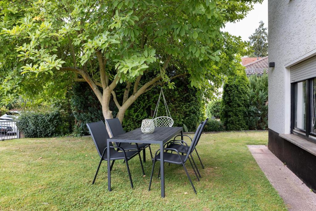a black table and chairs in a yard with a tree at Fewo Goldbach in Eschwege