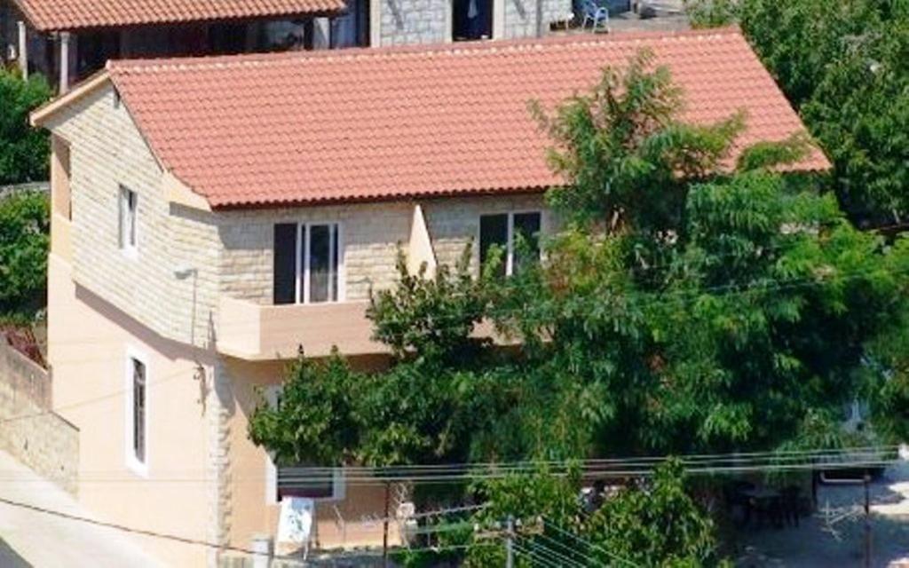 ein Haus mit rotem Dach auf einer Straße in der Unterkunft Apartment Sangaleti in Lastovo