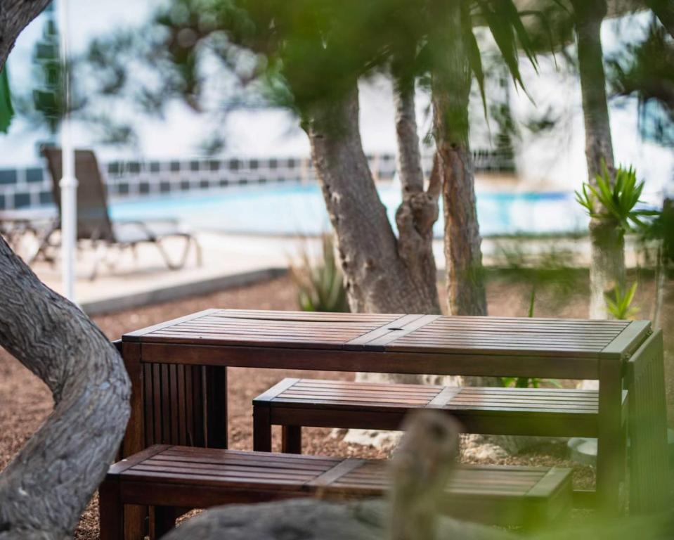 a wooden picnic table in front of a pool at Apartamento acogedor con Piscina en Tenerife in Icor