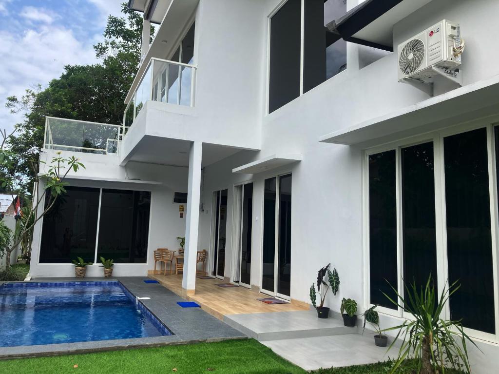 a white house with a swimming pool in front of it at D'illy Borobudur Villa in Magelang