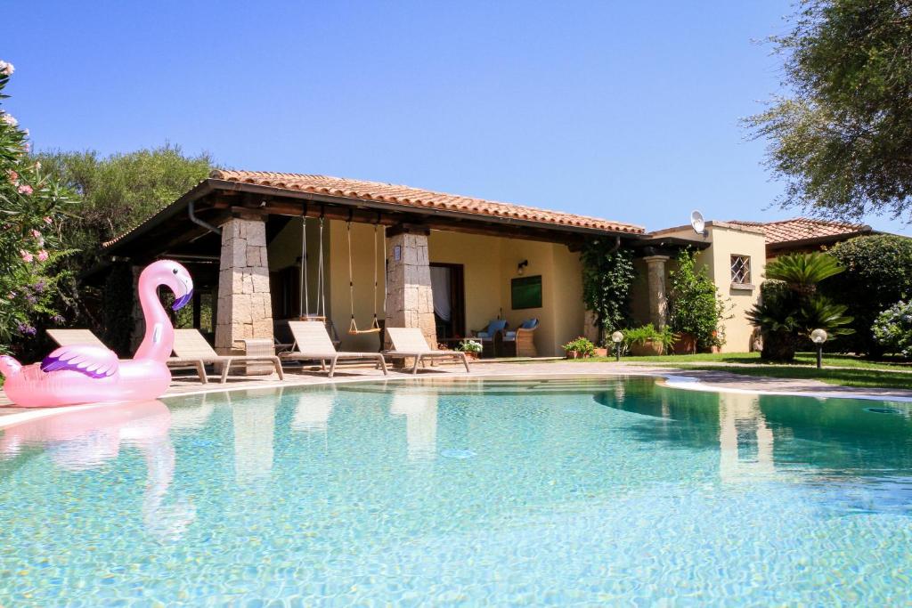 una piscina con cigno rosa in acqua di LuxRent Villa Smeralda Pool and Beach a Capo Coda Cavallo