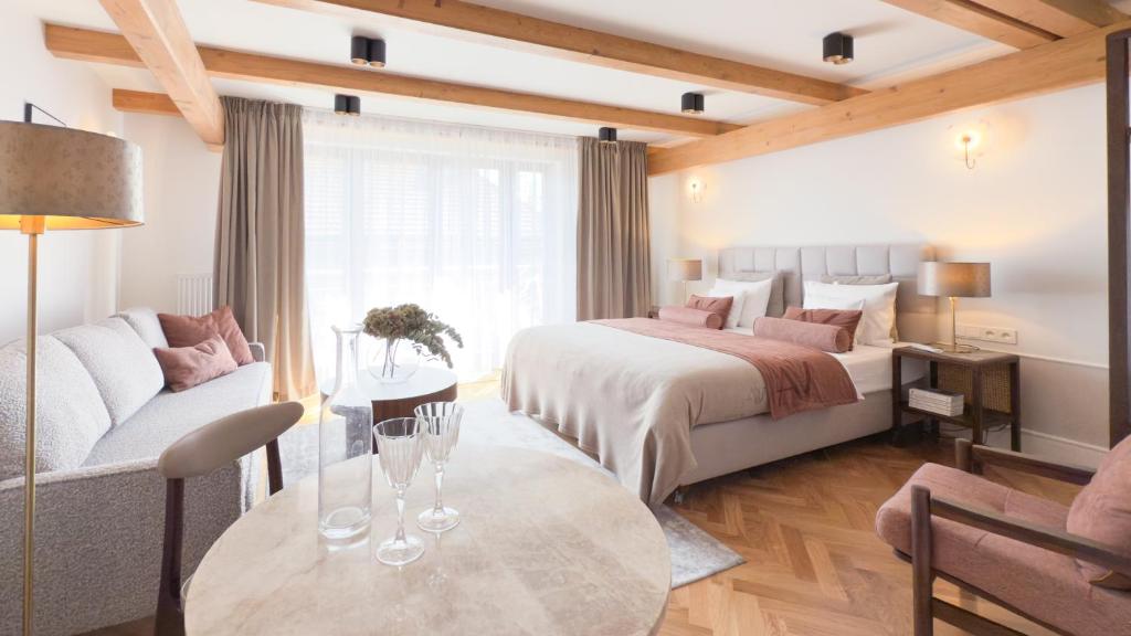 a hotel room with a bed and a couch and a table at Avanti Villa in Kraków