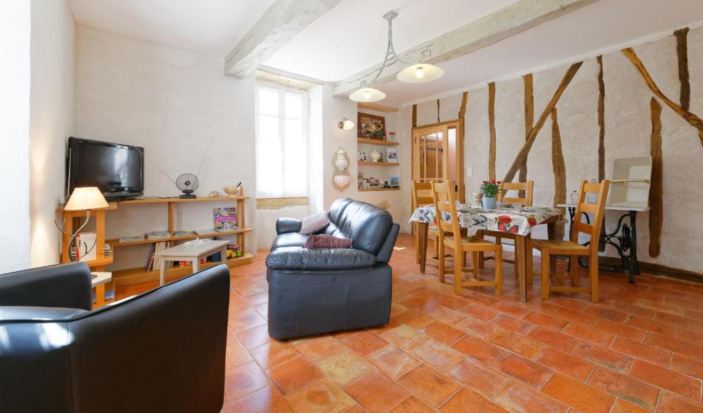 Una sala de estar con un sofá y un comedor. en Le Guitou de Monlezun, en Monlezun