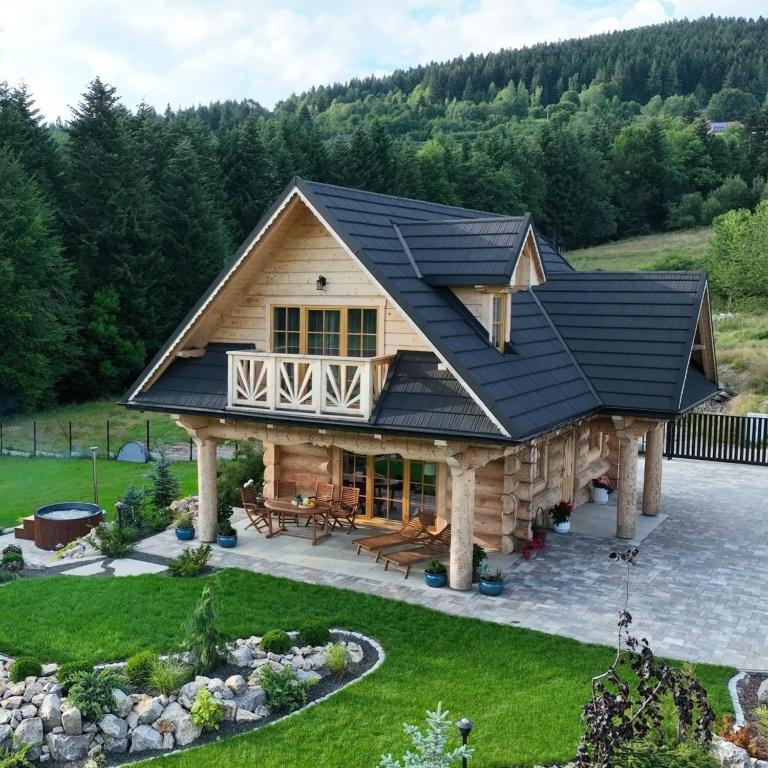 een grote blokhut met een zwart dak bij Leśny Zakątek Zawoja in Stryszawa