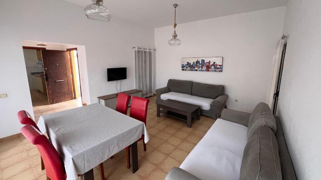 ein Wohnzimmer mit Sofa und Tisch in der Unterkunft Anahi Homes Corralejo- Dracaena 20 in La Oliva