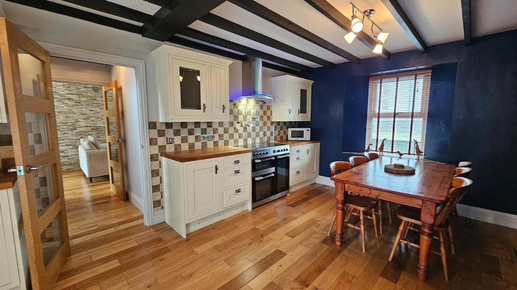 una cucina con un tavolo di legno e una sala da pranzo di Ffoswen Pembrokeshire Holiday Home a Boncath