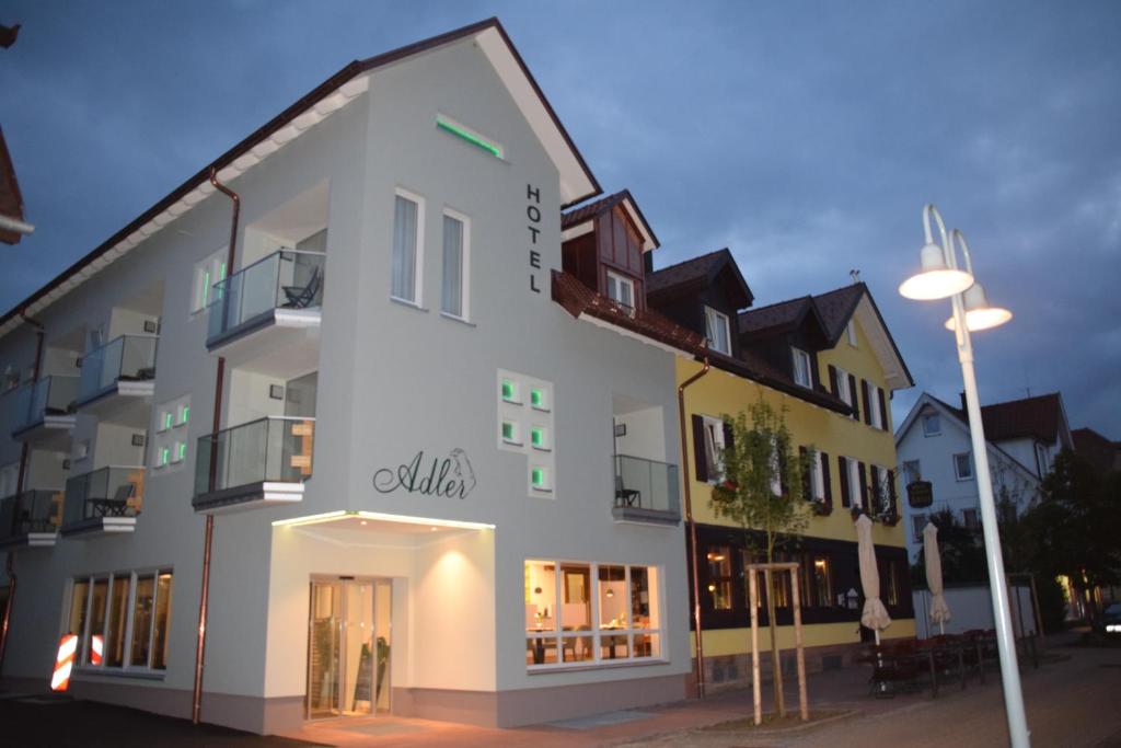 a white building with a street light in front of it at Hotel Adler in Freudenstadt