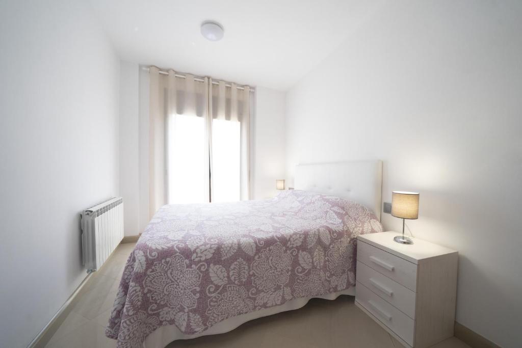 Una habitación blanca con una cama y una ventana en Apartamento centro histórico en Manresa, en Manresa