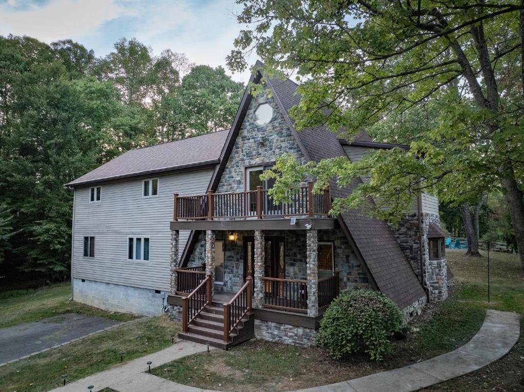 a house with a porch and a balcony at Horseshoe Acres - Home theater, spa room, hot tub in Oak Hill