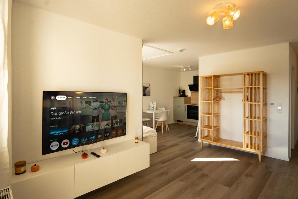 a living room with a flat screen tv on a wall at Auenblick -Natur genießen, Leipzig erleben in Leipzig