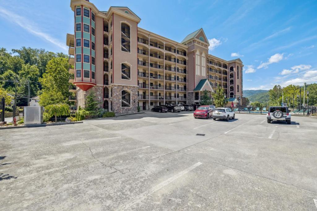 a large building with cars parked in a parking lot at Chillin By The Creek - Condo in Downtown Gatlinburg! in Gatlinburg