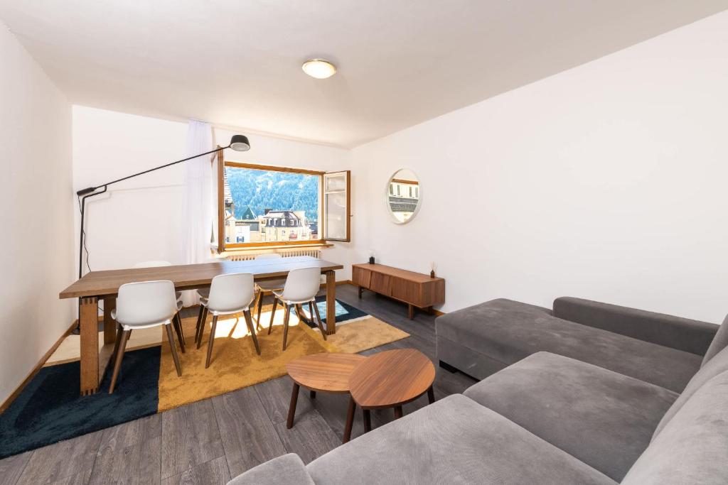 a living room with a table and a couch at Ski Paradise Steps to Chantarella Lift in St. Moritz