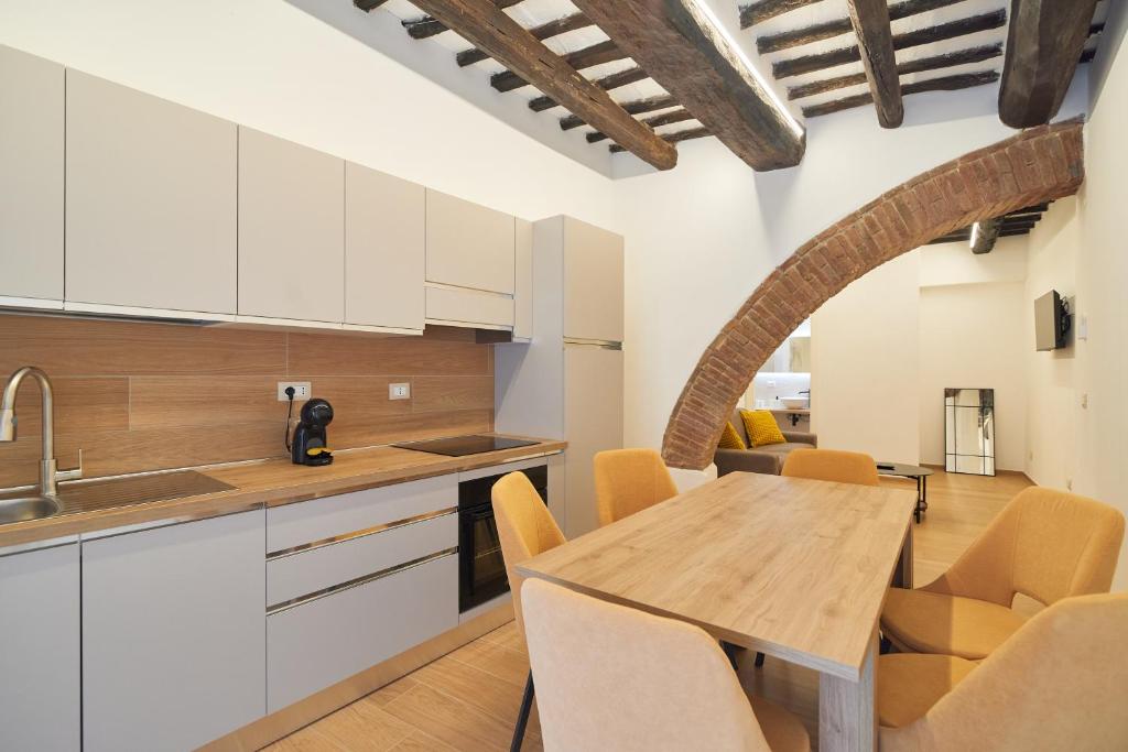 a kitchen and dining room with a table and chairs at AM13 - Design retreat in Perugia
