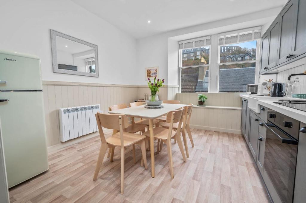 a kitchen and dining room with a table and chairs at Luxury 3BD Central Apt with Tower & Seaviews in Oban