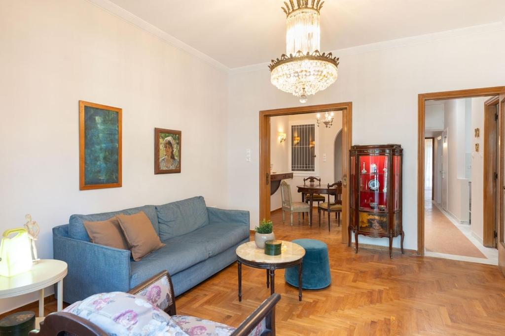 a living room with a blue couch and a table at Athenian Manor by Staycom in Athens