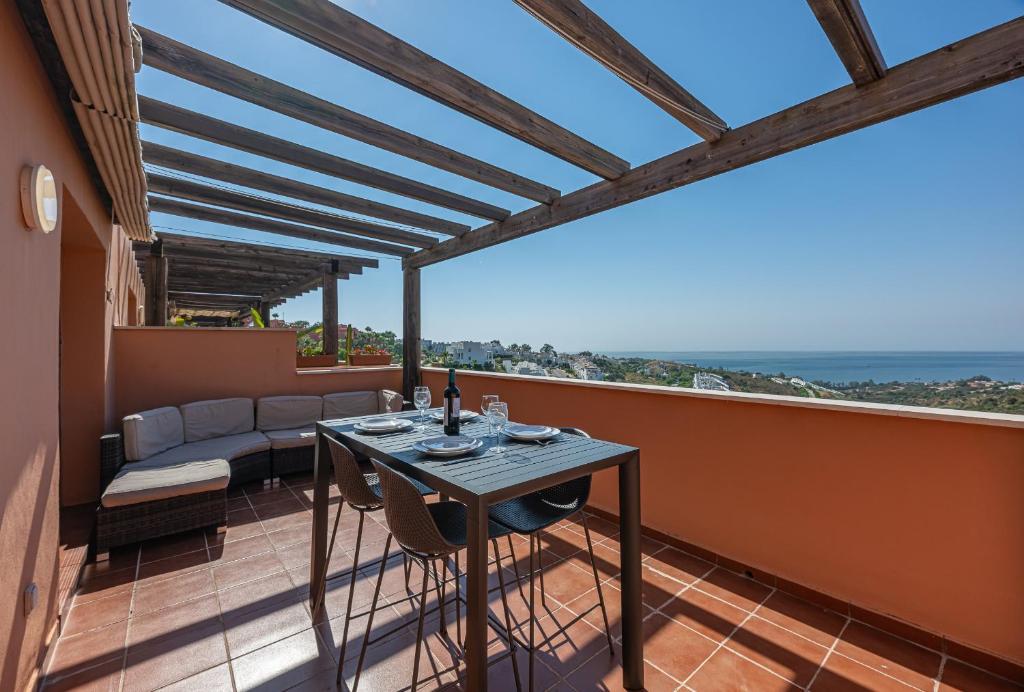 patio con mesa y sofá en el balcón en Rock Bay II 2456 SEA VIEW, en Sotogrande
