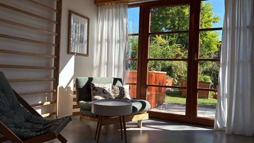 - un salon avec une chaise, une table et une fenêtre dans l'établissement Home apartment Konopiště, 