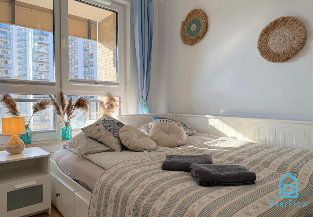 een slaapkamer met een bed met twee kussens erop bij Coast Apartment with Sauna & Gym, 5 Min to Baltic Sea & Polsat Plus Arena in Gdańsk