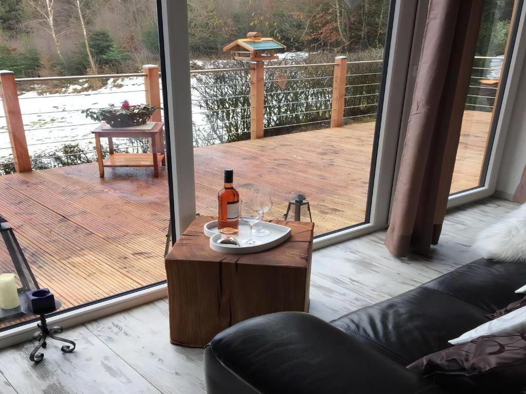 a bottle of wine sitting on a table on a deck at Herzhütte Für Zwei in Vichtenstein