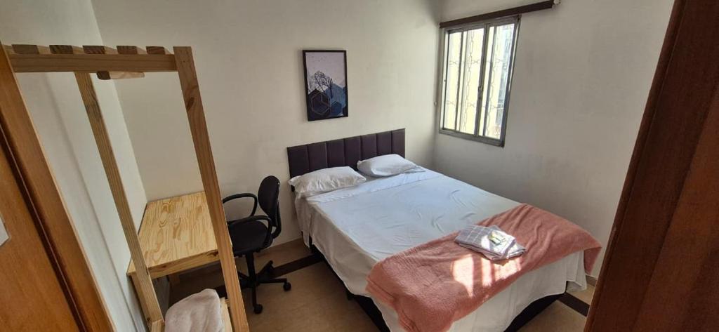 a small bedroom with a bed and a window at Quarto Clara in Sao Paulo