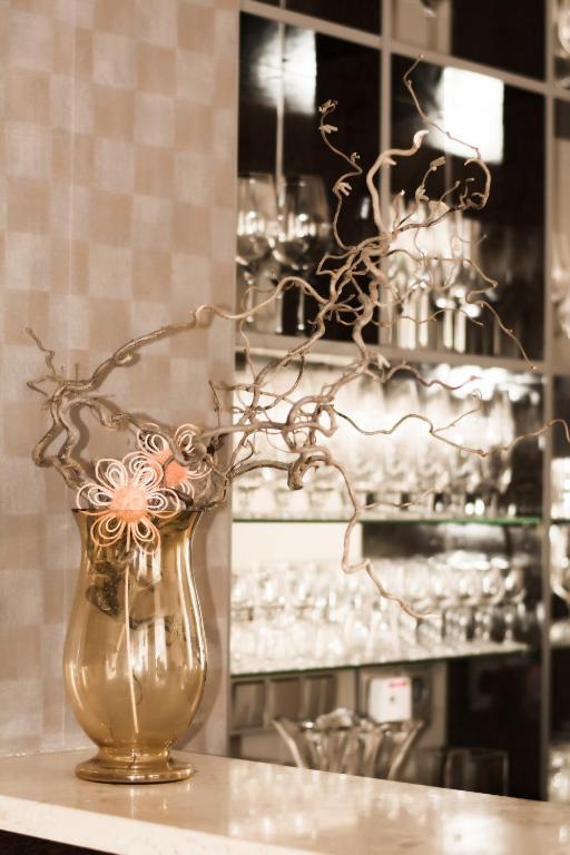 un vaso d'oro con dei fiori sul tavolo. di Hotel La Passionaria a Mariánské Lázně