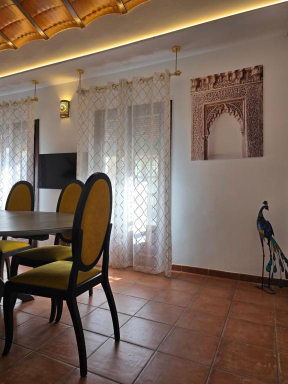 une salle à manger avec une table, des chaises et un oiseau sur le mur dans l'établissement Le Grand Sultan 1492, Mirador San Nicolás, Parking included, à Grenade