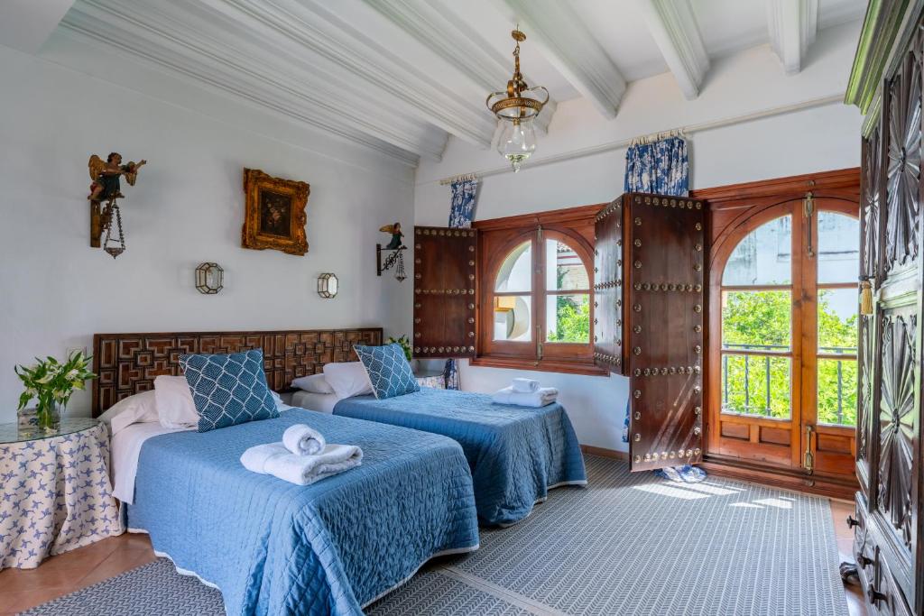 una camera da letto con due letti e una finestra di Villa Elvira, exclusive Pool and Gardens in the heart of Sevilla a Siviglia