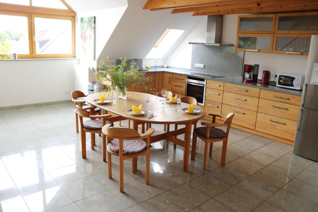 eine Küche mit einem Holztisch und Stühlen in der Unterkunft Apartment Dachgalerie in München