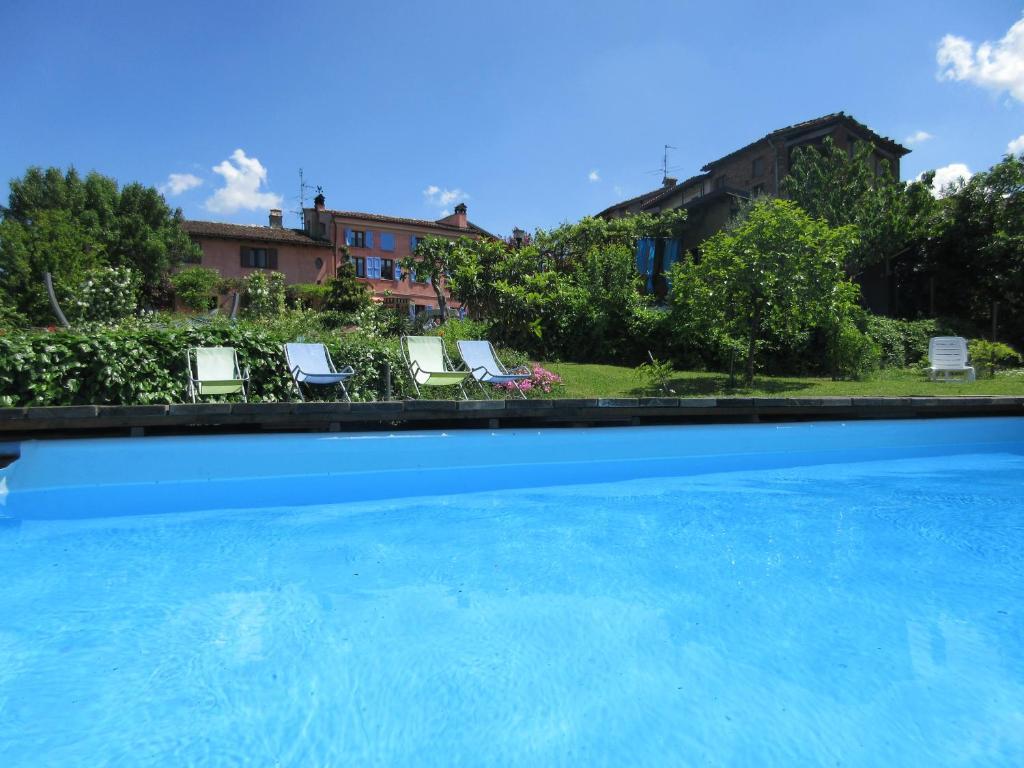 a swimming pool with chairs and a house in the background at Villa Gaia in Santa Maria della Versa