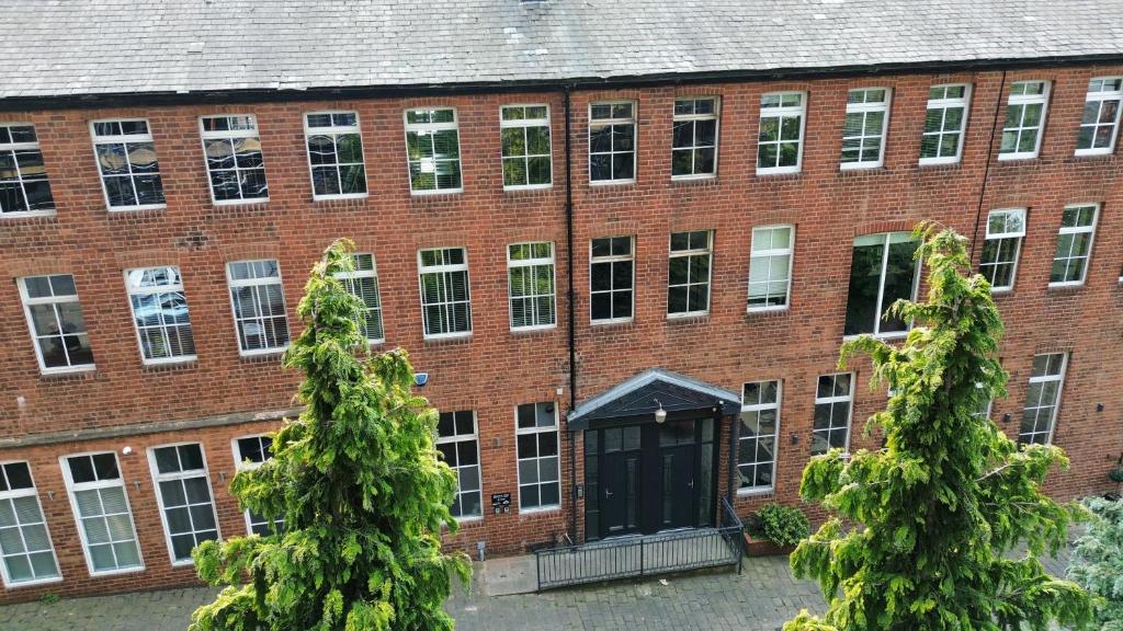 a large red brick building with a black door at The Hideout - Boutique 2 Bedroom Apartment in Sheffield