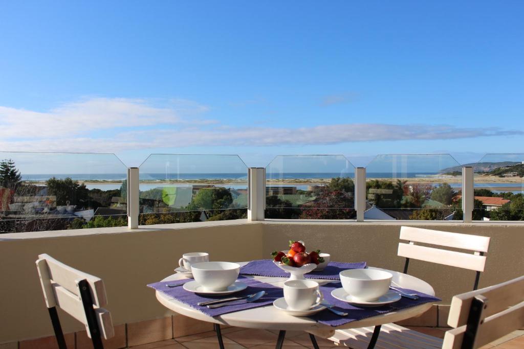 a table and chairs on a balcony with a view at Lagoon Terrace Penthouse with sea view in Plettenberg Bay