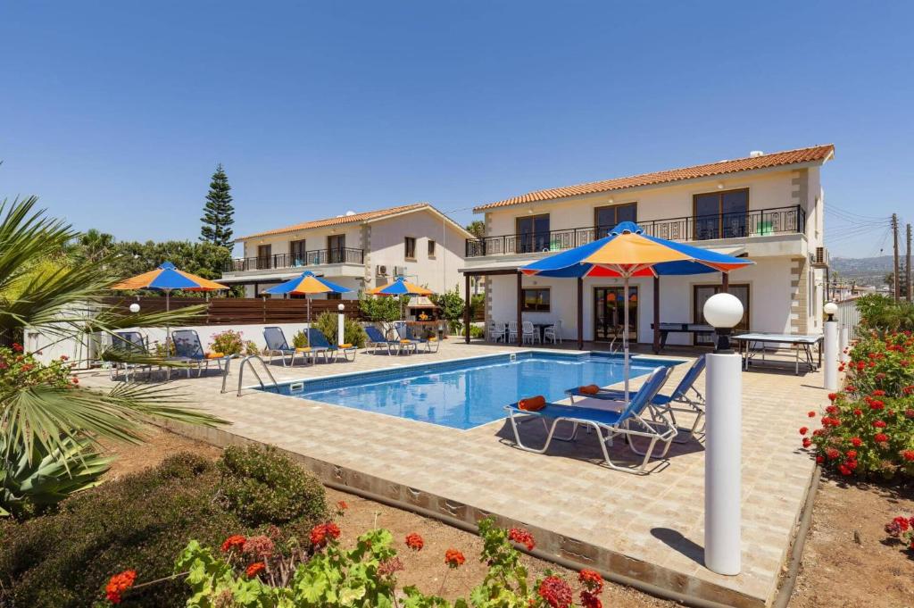 a villa with a swimming pool in front of a house at Villa Antonia by Villa Plus in Peyia