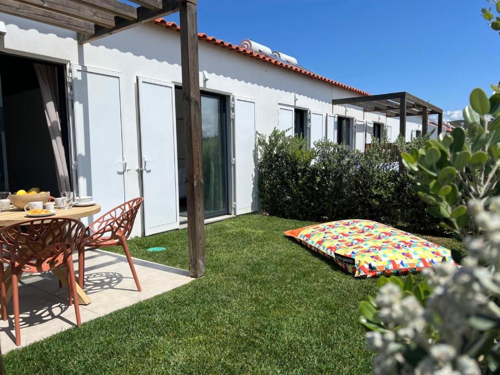 a backyard with a table and a blanket on the grass at Casa Beliche in Aljezur