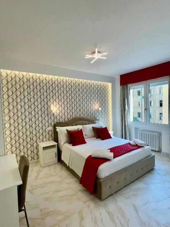 a bedroom with a large bed with red pillows at Safa Venice Station in Mestre
