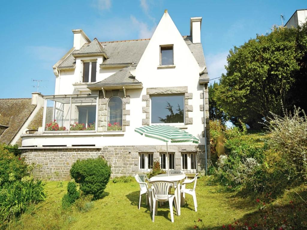 a house with a table and chairs in the yard at Seaside Comfort in Erquy in Erquy