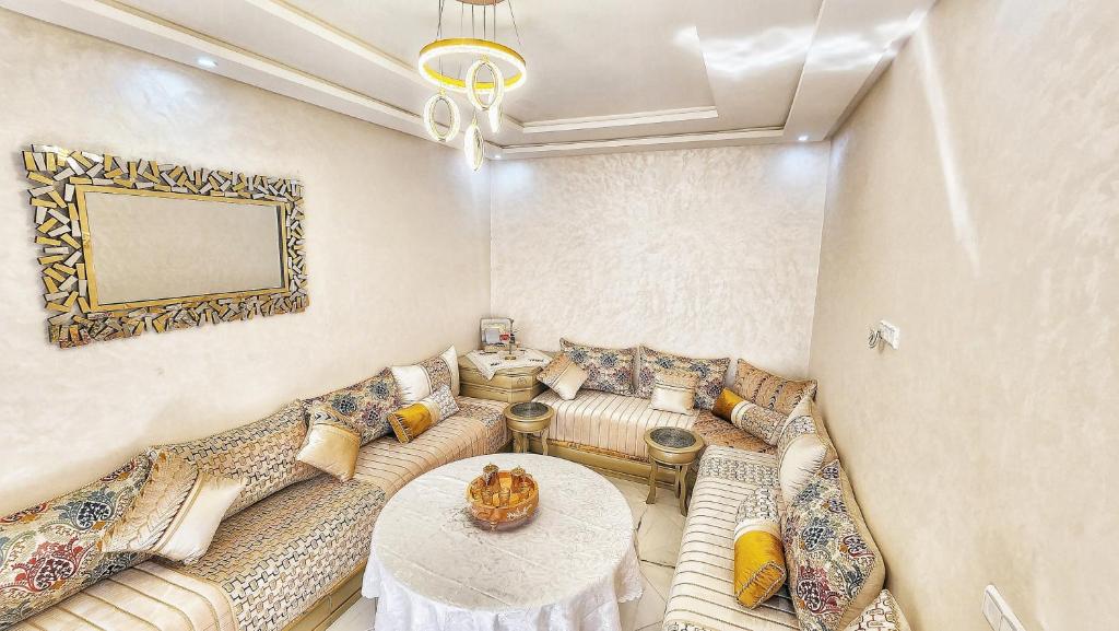 a living room with couches and a table at Appart calme près château rouge in El Jadida