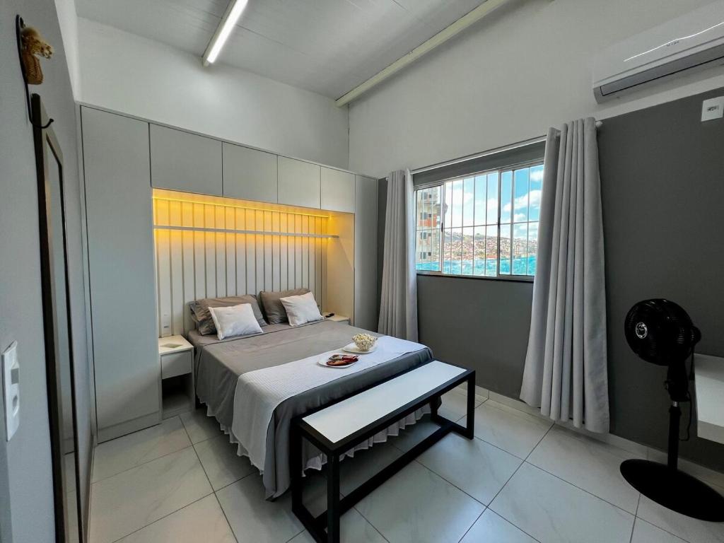 Un dormitorio con una cama y una ventana grande en Loft Sulfurosa - 800m do Parque das Águas, en São Lourenço