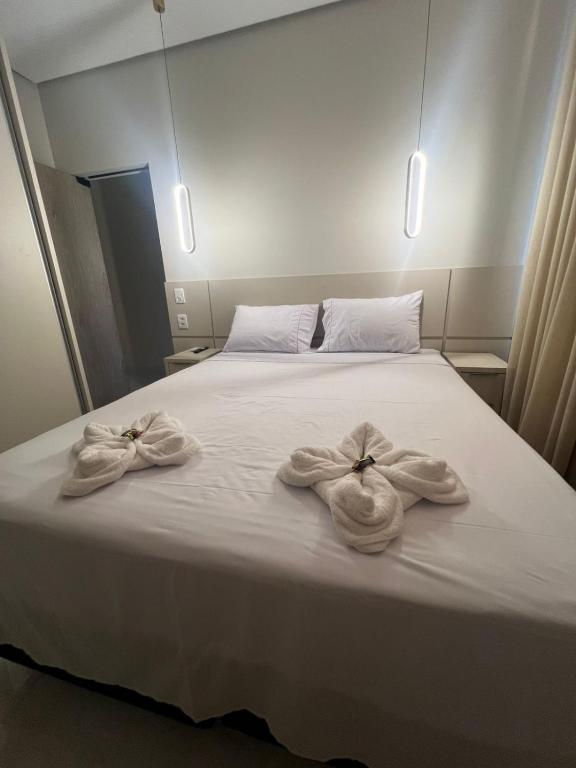 a bed with two towels on top of it at Apartamento Prime 02 in Palmas