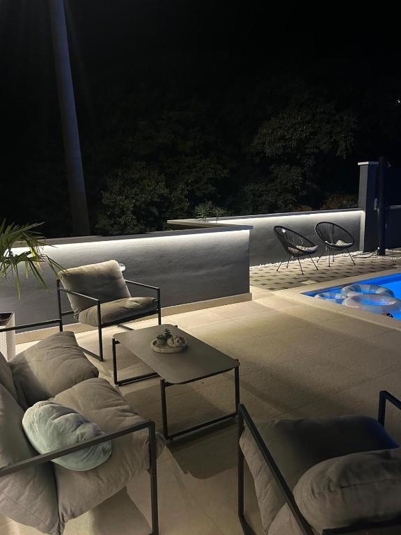 a patio with two couches and a table and chairs at Kuća za odmor ''ANA'' in Čitluk