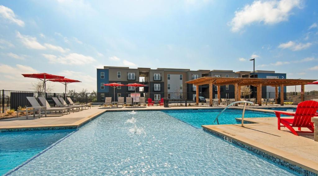 una piscina con sedie e ombrelloni e un edificio di Marble Flatz a Marble Falls