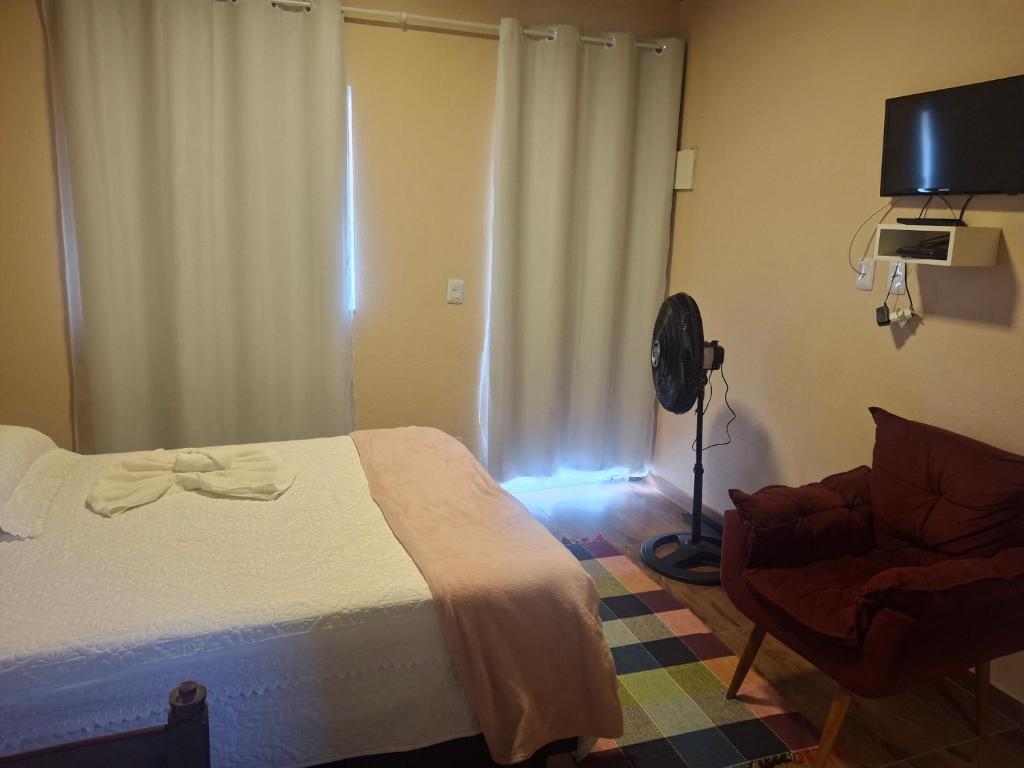 a bedroom with a bed and a chair and a fan at Casa de Luz - Lar na Serra - Suite - Duplo ou Triplo - N4 in Miguel Pereira