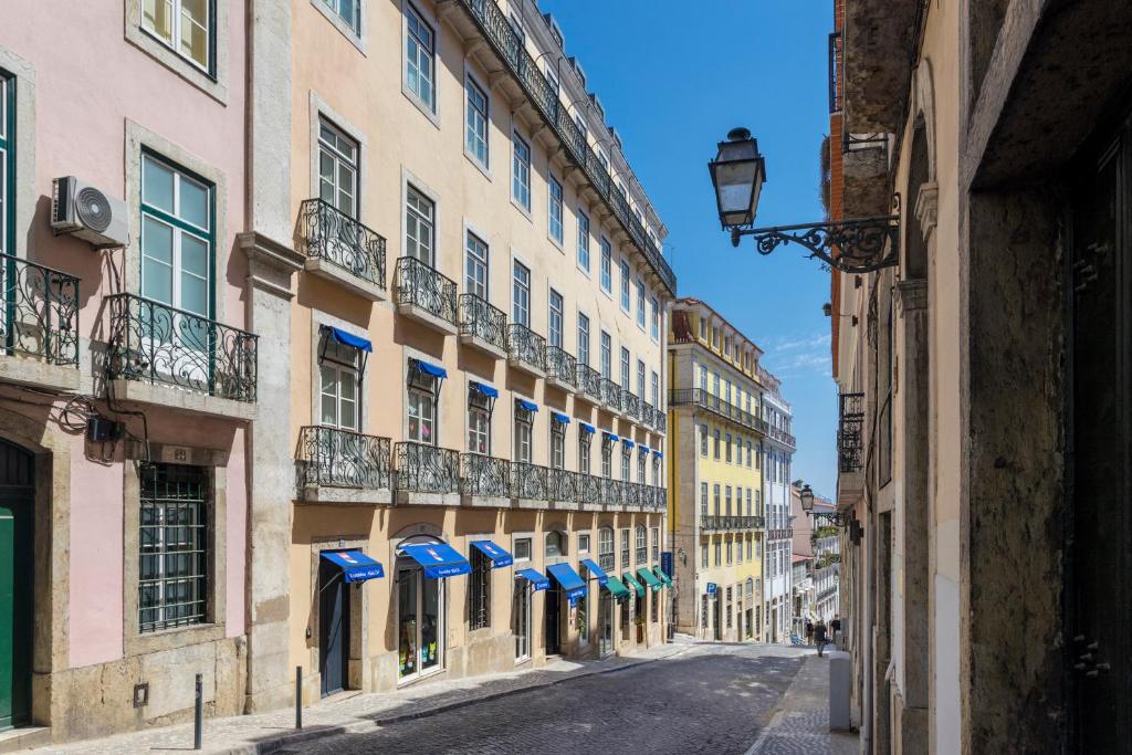 an empty street in a city with buildings at Martinhal Lisbon Chiado in Lisbon