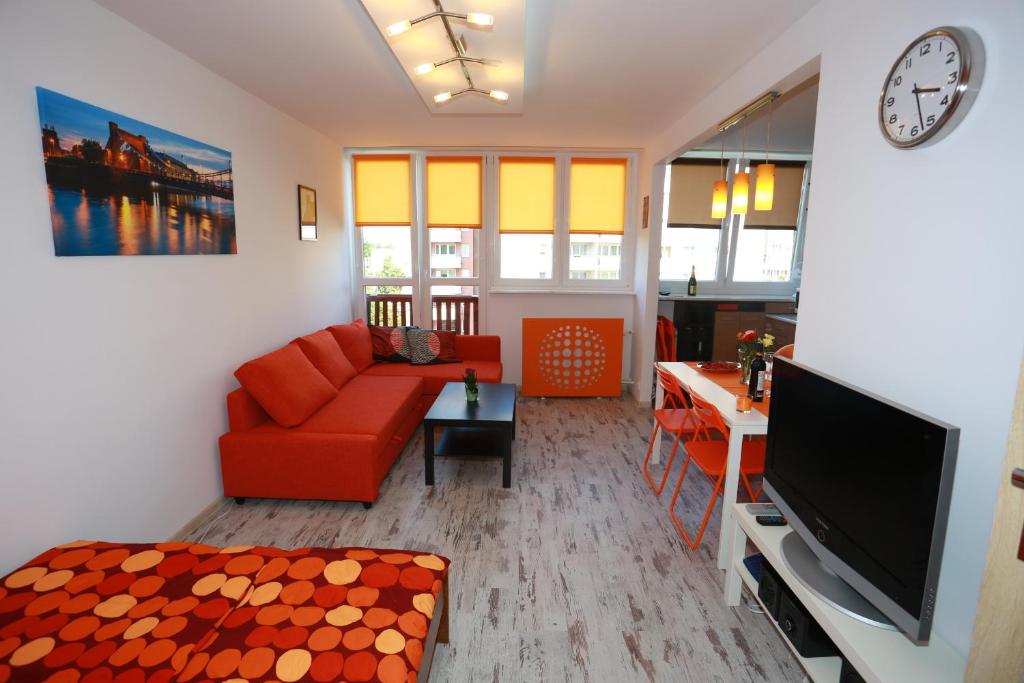 ヴロツワフにあるPod Mostemのリビングルーム(赤いソファ、テレビ付)