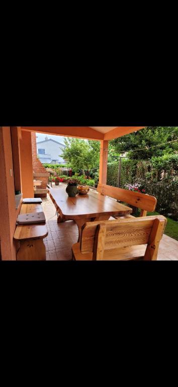 a wooden table and chairs with a laptop on it at Apartman Perka in Valbandon